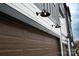 Close-up view of a two-car garage with updated carriage style door and modern lighting fixtures at 7940 Cedarsmith Ct, Charlotte, NC 28217
