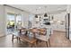 Bright, open kitchen and dining area with white cabinets, stainless appliances, and rustic wooden table at 110 Goorawing Ln, Mooresville, NC 28115