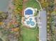 Aerial view of community amenities featuring a pool, sports field, and parking area surrounded by lush trees at 8505 Loxton Cir, Charlotte, NC 28214