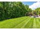 Large, manicured backyard with mature trees and green grass at 9618 Belloak Ln, Waxhaw, NC 28173