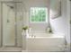 Bright bathroom with a soaking tub, separate shower, and large window at 9618 Belloak Ln, Waxhaw, NC 28173