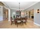 Well-lit dining room featuring a table set for six, crown molding, and views to the foyer and living spaces at 9618 Belloak Ln, Waxhaw, NC 28173