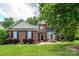 Beautiful two-story brick home with a well-maintained lawn and mature tree shading the facade at 9618 Belloak Ln, Waxhaw, NC 28173