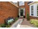 Inviting entryway features a black door, decorative wreath, and cozy bench with vibrant cushions at 9618 Belloak Ln, Waxhaw, NC 28173