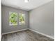 Empty bedroom with wood floors, neutral paint, and two windows overlooking the yard at 1105 Kenly St, Salisbury, NC 28144