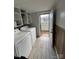 Functional laundry room with white cabinets, modern washer and dryer, and backyard access at 2100 Temple St, Kannapolis, NC 28081