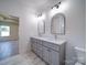 Bathroom boasts double vanity with gray cabinetry, modern mirrors and sconce lighting at 220 W Lawyers Rd, Monroe, NC 28110