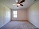 A cozy bedroom featuring plush carpeting, a ceiling fan, a window and a closet at 220 W Lawyers Rd, Monroe, NC 28110