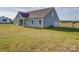Side view of blue house showing garage and driveway, against rural backdrop at 220 W Lawyers Rd, Monroe, NC 28110