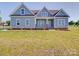 Charming light blue home featuring a well-manicured lawn and inviting front porch at 220 W Lawyers Rd, Monroe, NC 28110