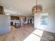 Open concept kitchen and dining area boasts stainless steel appliances and unique modern chandelier at 220 W Lawyers Rd, Monroe, NC 28110
