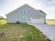 View of the side of the blue house, featuring a garage, side door and a lawn at 220 W Lawyers Rd, Monroe, NC 28110