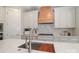 Bright kitchen with white cabinets, stainless steel sink, and wooden range hood at 4265 Candlewood Dr, Sherrills Ford, NC 28673