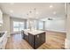 Open kitchen with island, white cabinets, and view to living area at 636 Edwards Rd, Fort Lawn, SC 29714
