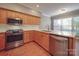 Well-lit kitchen with stainless steel appliances, wooden cabinets and stone countertops at 8468 Blades Trl, Denver, NC 28037