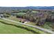Aerial view showcasing a house's peaceful setting near a road, surrounded by lush greenery and fields at 1485 Nc Hwy 16 N Hwy, Taylorsville, NC 28681