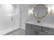 Bathroom with gray vanity, white herringbone tile shower, and gold mirror at 2192 Conner Cove Ln, Denver, NC 28037