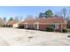 Brick exterior of a multi-unit building with a large concrete parking area in front on a sunny day at 1106 Chandler Dr, Rock Hill, SC 29732
