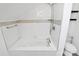 Bathtub with white tile surround and a handheld shower head at 12300 Caldwell Rd, Charlotte, NC 28213