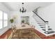 Elegant dining room with stylish chandelier, staircase, and view into the adjacent living room at 12300 Caldwell Rd, Charlotte, NC 28213