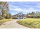 Charming home featuring a cozy front porch, surrounded by lush greenery and a winding driveway at 12300 Caldwell Rd, Charlotte, NC 28213
