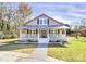 Inviting home with a classic covered porch, crisp white railings, and well-manicured front lawn at 12300 Caldwell Rd, Charlotte, NC 28213