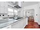 Bright kitchen features granite counters, white cabinets, stainless appliances, and hardwood floors at 12300 Caldwell Rd, Charlotte, NC 28213