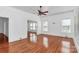 Empty living room featuring wood floors, white walls, and a view into the dining area at 12300 Caldwell Rd, Charlotte, NC 28213