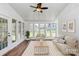 Cozy sunroom featuring ample sunlight, white trim and windows, a ceiling fan, and comfortable furnishings at 12300 Caldwell Rd, Charlotte, NC 28213