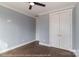 Bedroom featuring hardwood floors, blue walls, and two white closet doors at 4271 Candlewood Dr, Sherrills Ford, NC 28673