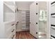 Large walk-in closet with built-in shelving and wood floors leading to bath at 4271 Candlewood Dr, Sherrills Ford, NC 28673