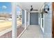 Inviting front porch with blue siding, white railings, ceiling fan, and stylish outdoor lighting fixture at 4271 Candlewood Dr, Sherrills Ford, NC 28673