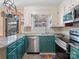 Updated kitchen with stainless steel appliances and teal cabinetry at 501 W Maryland Ave, Bessemer City, NC 28016