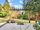 Wooden pergola with wind chimes overlooks a garden at 501 W Maryland Ave, Bessemer City, NC 28016