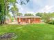 Spacious backyard with a lush lawn and brick exterior of the home at 7101 Ridgebrook Dr, Charlotte, NC 28210