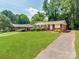Lovely brick home featuring a manicured front lawn and a paved driveway on a sunny day at 7101 Ridgebrook Dr, Charlotte, NC 28210