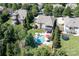 Aerial view of a beautiful home with a pool, lush landscaping, and mature trees in a serene setting at 14700 Old Vermillion Dr, Huntersville, NC 28078