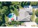 Aerial view of a private backyard with a large pool, patio, lush landscaping, and driveway at 14700 Old Vermillion Dr, Huntersville, NC 28078