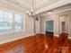 Bright living room featuring hardwood floors, elegant chandelier, and large windows; showcasing elegance and natural light at 14700 Old Vermillion Dr, Huntersville, NC 28078