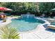 Inviting in-ground pool features lush landscaping, a rock waterfall, and plenty of lounge chairs at 14700 Old Vermillion Dr, Huntersville, NC 28078