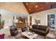 Open-concept living room showcases a stone accent wall, wood ceiling, staircase, and access to the kitchen at 5752 Natoma Rd, Lake Wylie, SC 29710