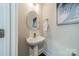Chic half-bath with pedestal sink, decorative mirror, and neutral paint at 947 Warren Burgess Ln, Charlotte, NC 28205