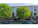 A multi-level townhouse featuring a brick facade, trees and parking at 947 Warren Burgess Ln, Charlotte, NC 28205