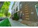 A modern townhome showcasing brick facade with light accents, set on a well-manicured street at 947 Warren Burgess Ln, Charlotte, NC 28205