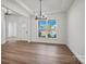 Elegant dining room showcasing modern chandelier, light hardwood floors, and a large window at 1065 Kinship Dr # 080, Lancaster, SC 29720