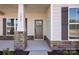 Inviting front porch with stone accents, classic pillars, and a beautifully stained front door at 1065 Kinship Dr # 080, Lancaster, SC 29720