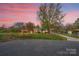 Charming single-story brick home with a long driveway, spacious yard, and beautiful mature trees at dusk at 130 Island Park Ln, Statesville, NC 28625