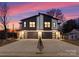 Modern two-story townhome exterior features stone accents and black garage doors at twilight at 2201 Catalina Ave, Charlotte, NC 28206