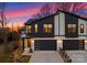 Modern two-story townhome exterior features stone accents and black garage doors at twilight at 2201 Catalina Ave, Charlotte, NC 28206