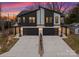 Modern two-story townhome exterior features stone accents and black garage doors at twilight at 2201 Catalina Ave, Charlotte, NC 28206